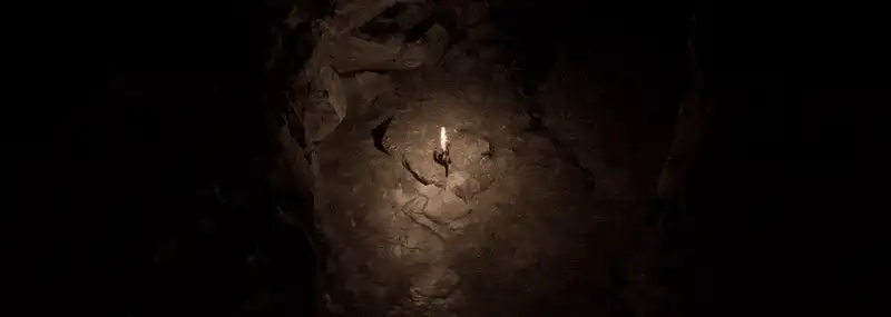 Une caverne obscure éclairée par la seule torche d'un joueur